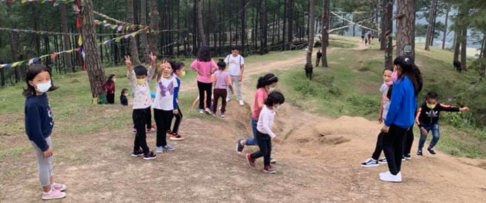 A group of children walking on a dirt path in a forest

Description automatically generated with low confidence